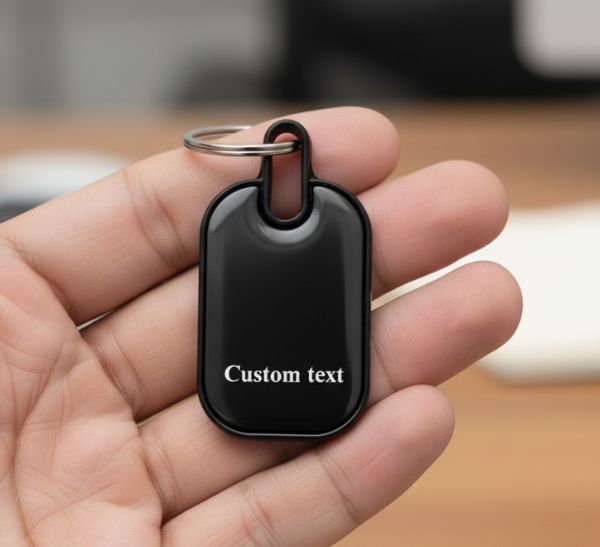 Black custom text keychain with double-side engraving held in hand