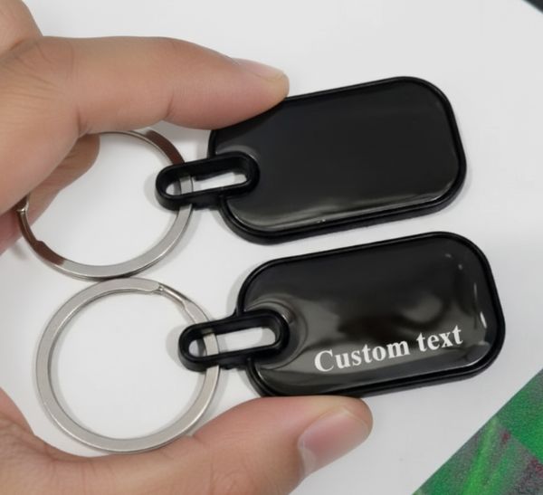 Black custom text keychain with double-side engraving held in hand